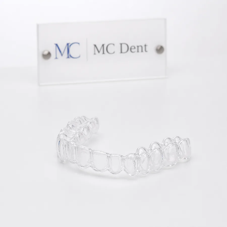 Contenção ortodôntica sobre mesa branca com placa MC Dent